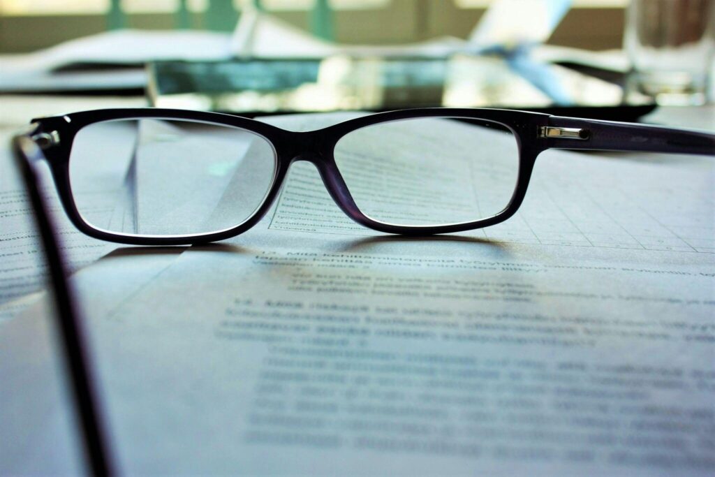 A reading glass laid on documents.