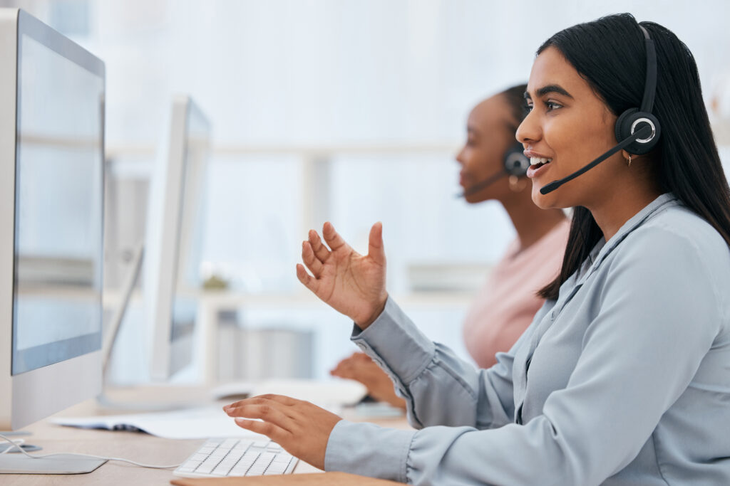 Call center, computer and woman talking at desk in telemarketing, customer service and CRM office. .