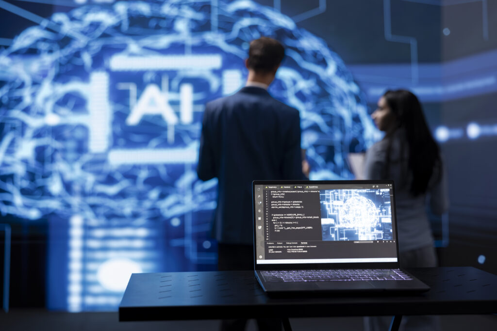 Focus on laptop running AI cognitive computing tech used by IT staff members in blurry background. Close up of notebook used by teamworking engineers to do data mining with self learning algorithms