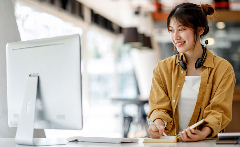 Image of a woman with headset in front of a computer, concept for retail